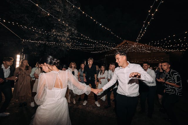 Nevěsta se ženichem na svatbě tančící na potemnělém tanečním parketě