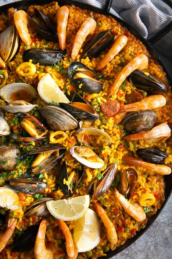 paella - mořské škeble s rýží a kořením na kulatém talíři