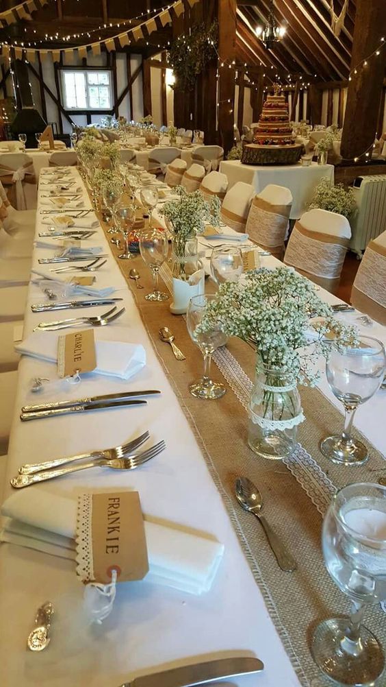 příbory prostřené na svatebním stole s dekoracemi, květinová výzdoba z bílých květin