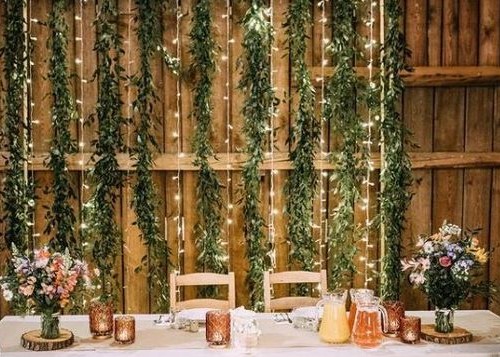 Svatební dekorace - svislý světelný LED řetěz na dřevěné stěně za svatební tabulí